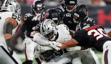 Las Vegas Raiders running back Mike Washington Jr., center, is stopped on a run against the Hou ...